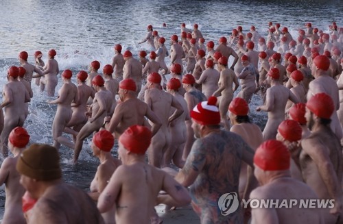 호주 겨울바다 수영축제에 참여한 시민들. 호주 태즈메이니아주 호바트 샌디 베이의 롱비치에서 열린 '다크 모토 페스티벌'(Dark Mofo Festival)에서 수영모만 쓴 시민들이 바다로 뛰어들고 있다 ⓒEPA 연합뉴스 자료사진