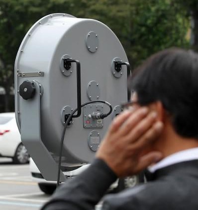 음향대포 시연회에서 참가자가 괴로운듯 귀를 막고 있다. ⓒ 연합뉴스