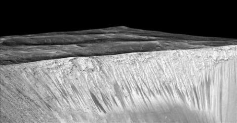 미국항공우주국(NASA)의 화성 괘도 정찰위성(MRO)에서 찍어 28일(현지시간) 공개한 사진. 화성 '가니' 분화구 벽면에 폭이 5m 내외, 길이가 수백m 정도의 가느다란 줄 형태들이 보인다. 과학자들은 영하 23도 이상으로 온도가 올라가면 생겼다가 그 아래로 온도가 내려가면 사라지는 것으로 보이는 이런 지형을 RSL(Recurring Slope Lineae)이라면서, RSL이 염화나트륨이나 염화마그네슘 등 염류를 포함한 물이 흐르면서 생기는 현상이라는 말했다.