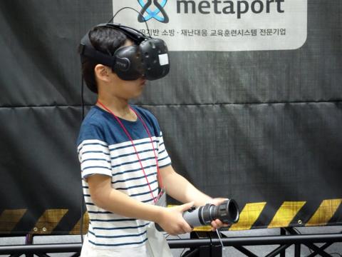 “나도 소방관!” 한 어린이가 헤드마운트디스플레이(HMD)를 착용하고 가상현실 재난프로그램으로 목조 사찰과 종합병원의 생생한 화재 현장에서 화재를 진화하는 체험을 하고 있다.